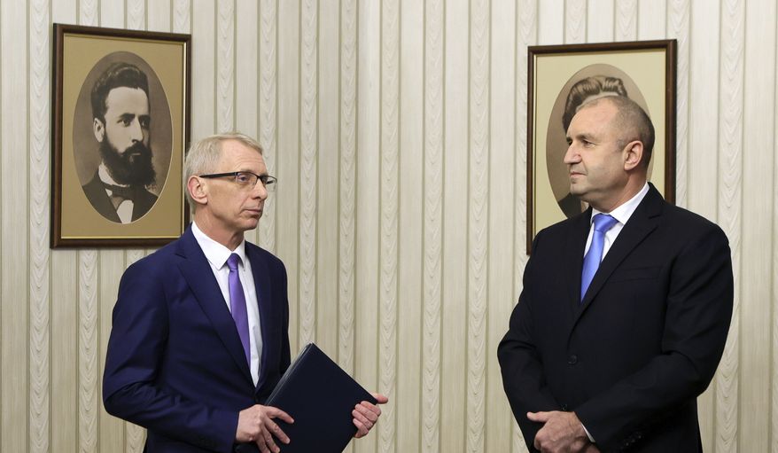 Bulgarian President Rumen Radev, right, looks at prime minister-designate Nikolay Denkov as he handed a mandate, at a ceremony in the Bulgarian Presidency, Sofia, Tuesday, Jan. 3, 2023. The second-largest political party in parliament to form a government to prevent the country from sliding to the fifth general elections in two years. (AP Photo/Valentina Petrova)