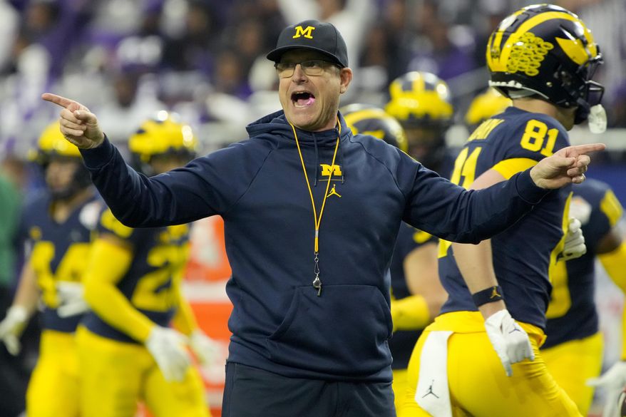 Michigan head coach Jim Harbaugh watches his players prior to the Fiesta Bowl NCAA college football semifinal playoff game against TCU, Saturday, Dec. 31, 2022, in Glendale, Ariz. (AP Photo/Rick Scuteri) **FILE**