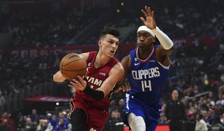 Miami Heat guard Tyler Herro, left, drives to the basket against Los Angeles Clippers guard Terance Mann during the first half of an NBA basketball game, Monday, Jan. 2, 2023, in Los Angeles. (AP Photo/Allison Dinner)