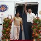 Philippine President Ferdinand Marcos Jr., right, waves beside wife Maria Louise as they board a plane for China on Tuesday, Jan. 3, 2023, at the Villamor Air Base in Manila, Philippines. (AP Photo/Aaron Favila)