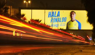 In this photo made with a slow shutter speed, a vehicle passes under a billboard showing Cristiano Ronaldo with Arabic wording which reads, Welcome Ronaldo, in Riyadh, Saudi Arabia, late Monday, Jan 2, 2023. Ronaldo completed a lucrative move to Saudi Arabian club Al Nassr on Friday in a deal that is a landmark moment for Middle Eastern soccer but will see one of Europe&#39;s biggest stars disappear from the sport&#39;s elite stage. (AP Photo/Amr Nabil)