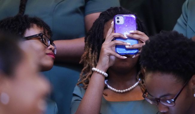 A member of the Jim Hill High School Choir uses her cellphone to photograph the rotunda of the Mississippi Capitol in Jackson, following an early morning performance prior to the start of the 2023 legislative session, Tuesday, Jan. 3, 2023. (AP Photo/Rogelio V. Solis)