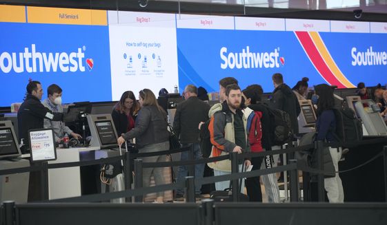 FILE - Travelers queue up at the check-in counters for Southwest Airlines in Denver International Airport, Friday, Dec. 30, 2022, in Denver. Southwest Airlines is trying to fix its relationship with travelers who got stuck by canceled flights over the holidays. On Tuesday, Jan. 3, 2023, Southwest told affected travelers that they will get 25,000 frequent-flyer points, which are worth more than $300 in tickets. (AP Photo/David Zalubowski, File)