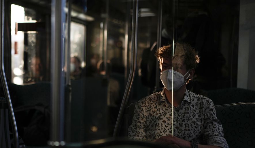 A man wearing a face mask to protect against coronavirus travels on a metro in Berlin, Germany, March 22, 2022. A German doctor has been sentenced to two years and nine months in prison for illegally issuing more than 4,000 people with exemptions from wearing masks during the coronavirus pandemic. (AP Photo/Pavel Golovkin, File)