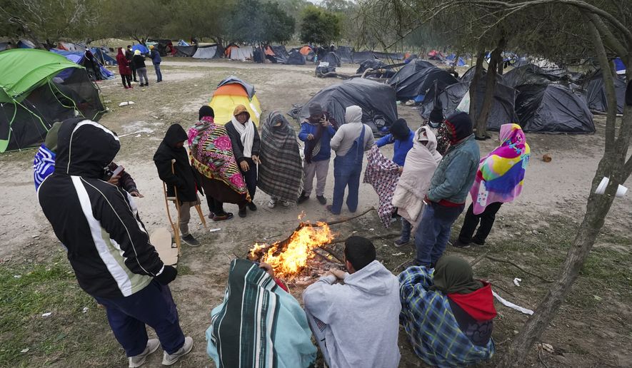 Migrants stand in the cold weather around a campfire at a makeshift camp on the U.S.-Mexico border in Matamoros, Mexico, Dec. 23, 2022, as they wait on a pending U.S. Supreme Court decision on asylum restrictions. The Biden administration on Thursday, Jan. 5, said it would immediately begin turning away Cubans, Haitians and Nicaraguans who cross the U.S.-Mexico border illegally, a major expansion of an existing effort to stop Venezuelans attempting to enter the U.S. (AP Photo/Fernando Llano) **FILE**
