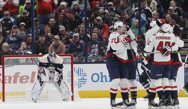 Washington Capitals players celebrate their goal against Columbus Blue Jackets&#x27; Elvis Merzlikins during the second period of an NHL hockey game on Thursday, Jan. 5, 2023, in Columbus, Ohio. (AP Photo/Jay LaPrete)