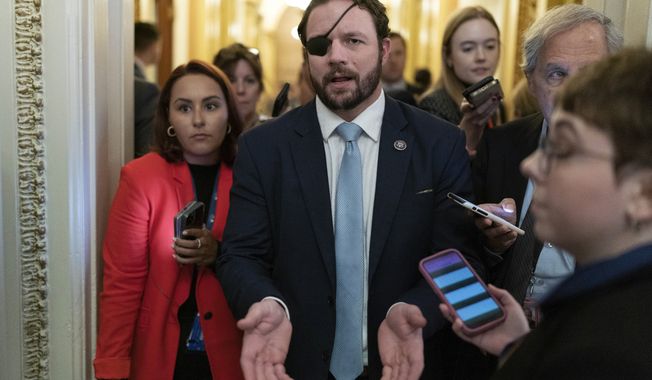 Rep. Dan Crenshaw, R-Texas, talks to reporters as he walks out of the House chamber as voting continued for a second day to elect a speaker and convene the 118th Congress in Washington, Wednesday, Jan. 4, 2023. (AP Photo/Jose Luis Magana)