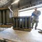U.S. Air Force Staff Sgt. Cody Brown, right, with the 436th Aerial Port Squadron, checks pallets of 155 mm shells ultimately bound for Ukraine, April 29, 2022, at Dover Air Force Base, Del. The U.S. will send $1.8 billion in military aid to Ukraine in a massive package that will for the first time include a Patriot missile battery and precision-guided bombs for their fighter jets, U.S. officials said Tuesday, Dec. 20, 2022, as the Biden administration prepares to welcome Ukrainian President Volodymyr Zelenskyy to Washington. (AP Photo/Alex Brandon, File)