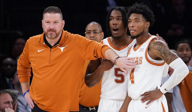Texas&#x27; head coach Chris Beard, left, meets with Tyrese Hunter (4) and Marcus Carr (5) at the bench during the first half of the team&#x27;s NCAA college basketball game against Illinois in the Jimmy V Classic, Tuesday, Dec. 6, 2022, in New York. Texas fired basketball coach Chris Beard on Thursday, Jan. 5, 2023, while he faces a felony domestic family violence charge stemming from a Dec. 12 incident involving his fiancée. (AP Photo/John Minchillo, File) **FILE**