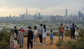 People visit the border of Hong Kong, with the skyline of China&#39;s Shenzhen in the background, in Hong Kong Feb. 13, 2021. Hong Kong will start to reopen its border with mainland China on Sunday, Jan. 8, 2023, allowing tens of thousands of people to travel between both sides each day under a quarantine-free arrangement, the city&#39;s leader said Thursday, Jan. 5. (AP Photo/Kin Cheung, File)