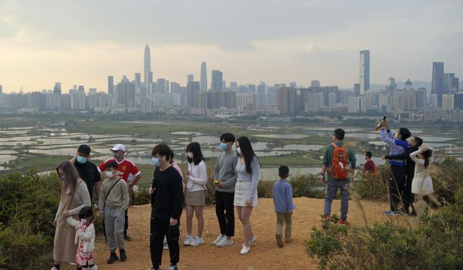 People visit the border of Hong Kong, with the skyline of China&#x27;s Shenzhen in the background, in Hong Kong Feb. 13, 2021. Hong Kong will start to reopen its border with mainland China on Sunday, Jan. 8, 2023, allowing tens of thousands of people to travel between both sides each day under a quarantine-free arrangement, the city&#x27;s leader said Thursday, Jan. 5. (AP Photo/Kin Cheung, File)