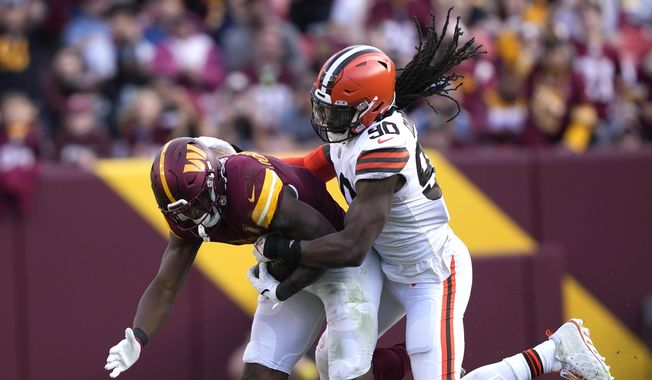 Cleveland Browns defensive end Jadeveon Clowney (90) tackles Washington Commanders running back Brian Robinson Jr. (8) during the second half of an NFL football game, Sunday, Jan. 1, 2023, in Landover, Md. (AP Photo/Susan Walsh)
