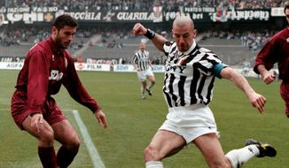 Former Italian national soccer team striker Gianluca Vialli, right, kicks the ball under the gaze of Torino&#x27;s defender Sean Sogliano during their Italian Serie A soccer match at the Delle Alpi stadium in Turin, Italy, Saturday, April 6, 1996. Gianluca Vialli, the former Italy striker who helped both Sampdoria and Juventus win Serie A and European trophies before becoming a player-manager at Chelsea, has died on Friday, Jan. 6, 2023. He was 58. (AP Photo/Mauro Pilone, File)