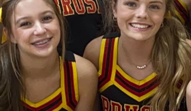 In this image provided by Janae Montgomery, Caroline Gill, left, and Maggie Dunn are shown in their cheerleading uniforms at Brusly High School in Brusly, Louisiana. Gill and Dunn were killed Saturday, Dec. 31, 2022, in a car crash. Authorities said a police officer from nearby Addis, La., crashed into the car the two girls were in after he joined a pursuit of a suspect that began in Baton Rouge. (Janae Montgomery via AP)
