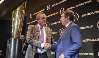 TCU head coach Sonny Dykes, left, speaks with Georgia head coach Kirby Smart after a news conference ahead of the national championship NCAA College Football Playoff game between Georgia and TCU, Sunday, Jan. 8, 2023, in Los Angeles. The championship football game will be played Monday. (AP Photo/Mike Stewart)