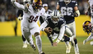 Dallas Cowboys quarterback Dak Prescott (4) leaping across with the ball to make the first down against Washington Commanders defensive tackle Daron Payne (94) during the first half an NFL football game, Sunday, Jan. 8, 2023, in Landover, Md. (AP Photo/Nick Wass)