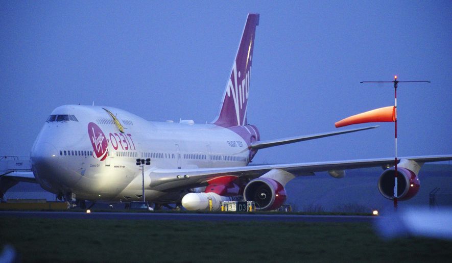 Virgin Atlantic Cosmic Girl, a repurposed Virgin Atlantic Boeing 747 aircraft carrying a rocket, is parked at Spaceport Cornwall, at Cornwall Airport in Newquay, England, Monday, Jan. 9, 2023. Engineers are making final preparations for the first satellite launch from the U.K. later Monday, when a repurposed passenger plane is expected to release a Virgin Orbit rocket carrying several small satellites into space. (Ben Birchall/PA via AP)