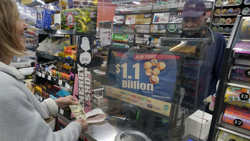 A Mega Millions customer purchases her tickets for the estimated jackpot of $1.1 Billion at the Fuel On Convenience Store in Pittsburgh, Monday, Jan. 9, 2023. (AP Photo/Gene J. Puskar)