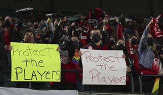 Portland Thorns fans hold signs during the first half of the team&#39;s National Women&#39;s Soccer League soccer match against the Houston Dash in Portland, Ore., Oct. 6, 2021. An investigation commissioned by the NWSL and its players union found “widespread misconduct&quot; directed at players dating back to the beginnings nearly a decade ago of the country&#39;s top women&#39;s professional league. (AP Photo/Steve Dipaola, File) **FILE**