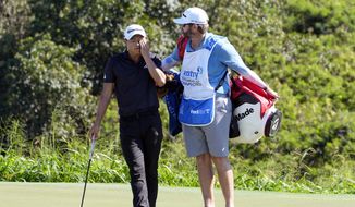 Collin Morikawa stands with his caddie on the 18th green during the final round of the Tournament of Champions golf event, Sunday, Jan. 8, 2023, at Kapalua Plantation Course in Kapalua, Hawaii. (AP Photo/Matt York) **FILE**