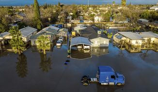 Following days of rain, floodwaters surround homes and vehicles in the Planada community of Merced County, Calif., on Tuesday, Jan. 10, 2023. (AP Photo/Noah Berger)