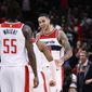 Washington Wizards forward Kyle Kuzma, right, reacts with guard Monte Morris, center, and guard Delon Wright (55) after he made a 3-pointer during the closing seconds of the team&#39;s NBA basketball game against the Chicago Bulls, Wednesday, Jan. 11, 2023, in Washington. The Wizards won 100-97. (AP Photo/Nick Wass)