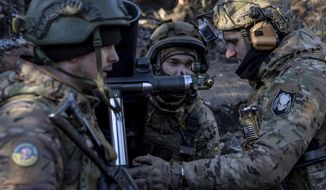 Ukrainian servicemen prepare to fire a 120 mm mortar towards Russian positions at the frontline near Bakhmut, Donetsk region, Ukraine, Wednesday, Jan. 11, 2023. (AP Photo/Evgeniy Maloletka)