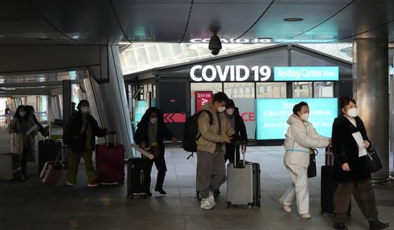 Passengers arriving from China pass by a COVID-19 testing center at the Incheon International Airport In Incheon, South Korea, Tuesday, Jan. 10, 2023. Chinese embassies stopped issuing new visas for South Koreans and Japanese on Tuesday in apparent retaliation for COVID-19 measures recently imposed by those countries on travelers from China. (AP Photo/Ahn Young-joon)