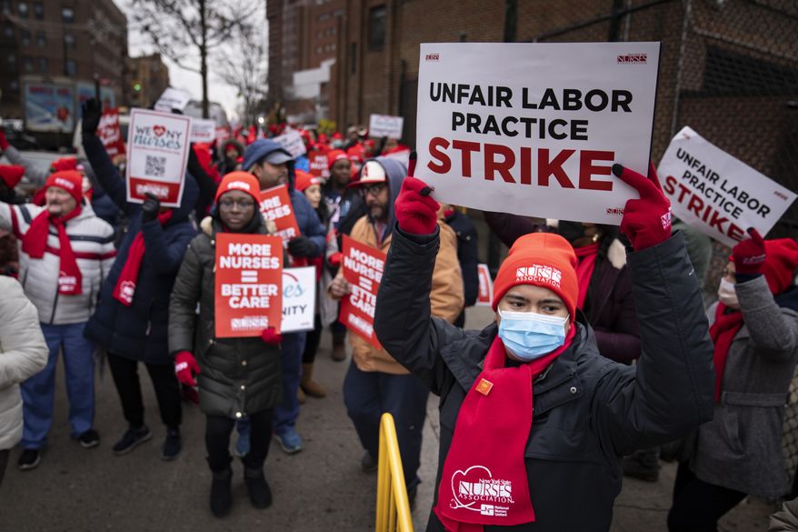 Protestors march on the streets around Montefiore Medical Center during a nursing strike, Wednesday, Jan. 11, 2023, in the Bronx borough of New York. (AP Photo/John Minchillo)