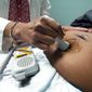 A doctor uses a hand-held Doppler probe on a pregnant woman to measure the heartbeat of the fetus on Dec. 17, 2021, in Jackson, Miss. (AP Photo/Rogelio V. Solis) **FILE**