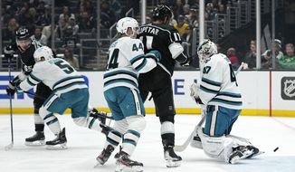 Los Angeles Kings center Quinton Byfield, left, scores on San Jose Sharks goaltender James Reimer, right, as defenseman Matt Benning, second from left, defenseman Marc-Edouard Vlasic, center, and center Anze Kopitar watch during the first period of an NHL hockey game Wednesday, Jan. 11, 2023, in Los Angeles. (AP Photo/Mark J. Terrill)