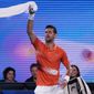 Serbia&#39;s Novak Djokovic swings his towel as he dances between games during an exhibition match against Australia&#39;s Nick Kyrgios on Rod Laver Arena ahead of the Australian Open tennis championship in Melbourne, Australia, Friday, Jan. 13, 2023. (AP Photo/Mark Baker)