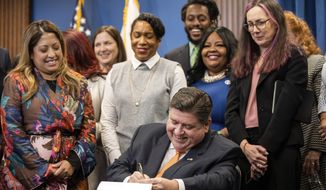 Illinois Gov. J.B. Pritzker signs House Bill 4664, a bill that will further protect reproductive health care providers and patients who are seeking care in Illinois, Friday, Jan. 13, 2023, in Chicago. (Pat Nabong/Chicago Sun-Times via AP)