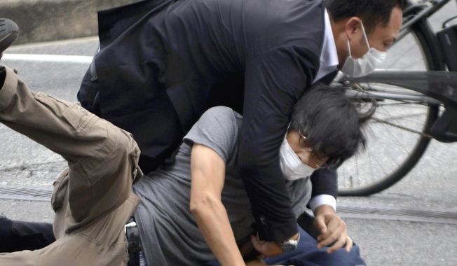Tetsuya Yamagami, bottom, is detained near the site of gunshots in Nara Prefecture, western Japan, on July 8, 2022. Japanese prosecutors formally charged the suspect in the assassination of former Prime Minister Shinzo Abe with murder, Japan&#x27;s NHK public television reported Friday, Jan. 13, 2023. (Katsuhiko Hirano/The Yomiuri Shimbun via AP, File)