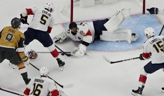 Florida Panthers goaltender Sergei Bobrovsky (72) attempts to cover the puck against the Vegas Golden Knights during the first period of an NHL hockey game Thursday, Jan. 12, 2023, in Las Vegas. (AP Photo/John Locher)