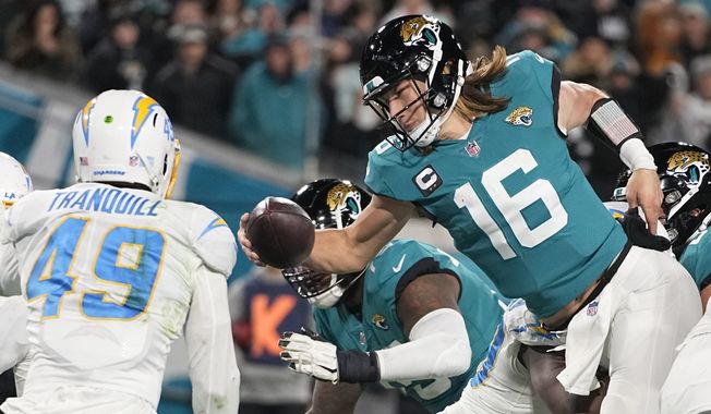 Jacksonville Jaguars quarterback Trevor Lawrence (16) leaps for a two-point conversion against the Los Angeles Chargers during the second half of an NFL wild-card football game, Saturday, Jan. 14, 2023, in Jacksonville, Fla. (AP Photo/Chris Carlson)