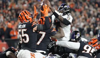 Baltimore Ravens quarterback Tyler Huntley, right, fumbles the ball as it is knocked away by Cincinnati Bengals linebacker Logan Wilson (55) in the second half of an NFL wild-card playoff football game in Cincinnati, Sunday, Jan. 15, 2023. The Bengals&#39; Sam Hubbard recovered the fumble and ran it back for a touchdown. (AP Photo/Joshua A. Bickel)