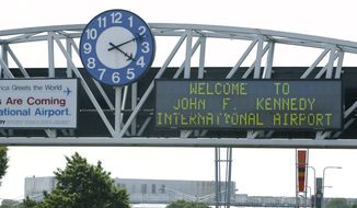 A clock at the entrance to JFK Airport in New York is pictured on Aug. 15, 2003. Officials are investigating a close call at the New York airport that happened Friday, Jan. 13, 2023, between a plane that was crossing a runway and another that was preparing for takeoff. (AP Photo/Stuart Ramson, File)