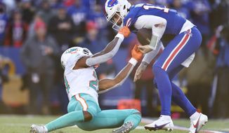 Miami Dolphins safety Eric Rowe (21), left, hangs onto Buffalo Bills quarterback Josh Allen (17) before knocking the ball loose during the second half of an NFL wild-card playoff football game, Sunday, Jan. 15, 2023, in Orchard Park, N.Y. Miami Dolphins defensive tackle Zach Sieler recovered the ball for a touchdown on the play. (AP Photo/Adrian Kraus)