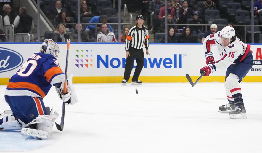 Washington Capitals&#x27; Sonny Milano (15) shoots as New York Islanders goaltender Ilya Sorokin (30) protects his net during the first period of an NHL hockey game Monday, Jan. 16, 2023, in Elmont, N.Y. (AP Photo/Frank Franklin II)