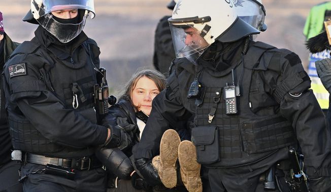 Police officers carry Swedish climate activist Greta Thunberg away from the edge of the Garzweiler II opencast lignite mine during a protest action by climate activists after the clearance of Luetzerath, Germany, Tuesday, Jan. 17, 2023. After the eviction of Luetzerath ended on Sunday, coal opponents continued their protests on Tuesday at several locations in North Rhine-Westphalia. (Federico Gambarini/dpa via AP)