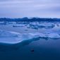 A boat navigates at night next to large icebergs near the town of Kulusuk, in eastern Greenland on Aug. 15, 2019.  A sharp spike in Greenland temperatures since 1995 showed the giant northern island 2.7 degrees (1.5 degrees Celsius) hotter than its 20th-century average, the warmest in more than 1,000 years, according to new ice core data. (AP Photo/Felipe Dana, File)