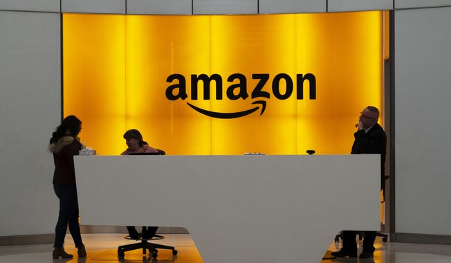 In this Feb. 14, 2019, photo, people stand in the lobby for Amazon offices in New York. (AP Photo/Mark Lennihan) **FILE**