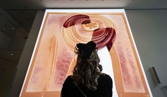A visitor looks at artist  Refik Anadol&#x27;s &quot;Unsupervised&quot; exhibit at the Museum of Modern Art, Wednesday, Jan. 11, 2023, in New York. The new AI-generated installation is meant to be a thought-provoking interpretation of the New York City museum&#x27;s prestigious collection. (AP Photo/John Minchillo)