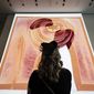 A visitor looks at artist  Refik Anadol&#39;s &quot;Unsupervised&quot; exhibit at the Museum of Modern Art, Wednesday, Jan. 11, 2023, in New York. The new AI-generated installation is meant to be a thought-provoking interpretation of the New York City museum&#39;s prestigious collection. (AP Photo/John Minchillo)