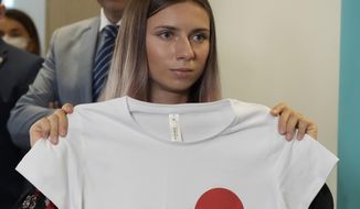 Belarusian Olympic sprinter Krystsina Tsimanouskaya, who arrived in Poland fearing reprisals at home after criticizing her coaches at the Tokyo Games, holds up an Olympic-related T-shirt with the slogan &quot;I Just Want to Run&quot; after her news conference in Warsaw, Poland, Thursday, Aug. 5, 2021. The Belarusian track coach who tried to force the sprinter out of the Tokyo Olympics and back to Belarus after she was critical of the team has been charged with breaching the sport&#39;s integrity standards. The Athletics Integrity Unit announced the charges against Yury Maisevich on Thursday, Jan. 19, 2023. (AP Photo/Czarek Sokolowski, File)