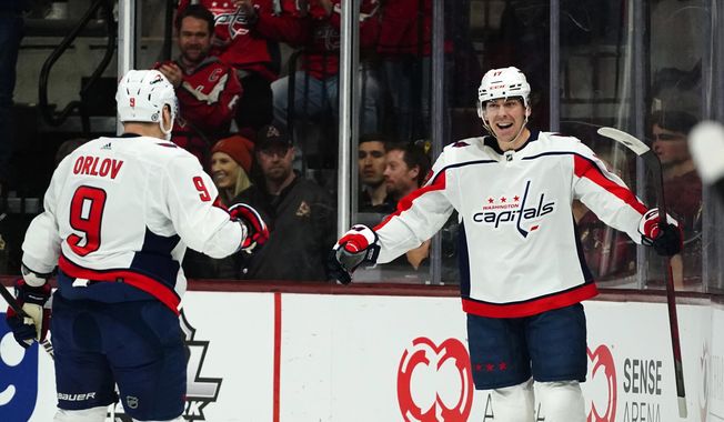 Washington Capitals center Dylan Strome smiles as he celebrates his goal against the Arizona Coyotes with defenseman Dmitry Orlov (9) during the first period of an NHL hockey game in Tempe, Ariz., Thursday, Jan. 19, 2023. (AP Photo/Ross D. Franklin)