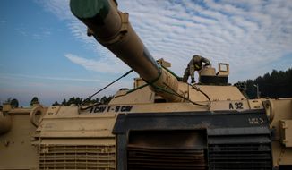 In this Oct. 21, 2019, photo, a member of the U.S. Army&#39;s 1st Armored Battalion of the 9th Regiment, 1st Division from Fort Hood in Texas prepares to unload Abrams battle tanks from rail cars as they arrive at the Pabrade railway station some 50 km (31 miles) north of the capital Vilnius, Lithuania. (AP Photo/Mindaugas Kulbis) **FILE**