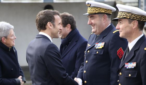 French President Emmanuel Macron shakes hands with Gen. Stephane Mille, second right, before his New Year address to the French Army, Friday, Jan. 20, 2023 at the Mont-de-Marsan air base, southwestern France. President Emmanuel Macron is expected to unveil his vision for modernizing the military in his nuclear-armed country, taking into account the impact of the war in Ukraine and evolving threats around the world. (AP Photo/Bob Edme, Pool)