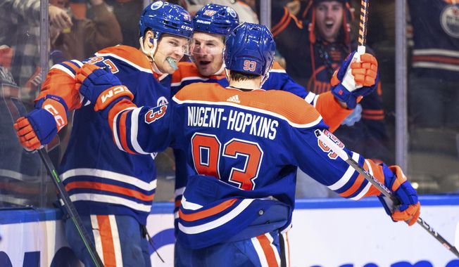 Edmonton Oilers&#x27; Warren Foegele (37), Ryan Nugent-Hopkins (93) and Zach Hyman (18) celebrate a goal against the Tampa Bay Lightning during the second period of an NHL hockey game Thursday, Jan. 19, 2023, in Edmonton, Alberta. (Jason Franson/The Canadian Press via AP)
